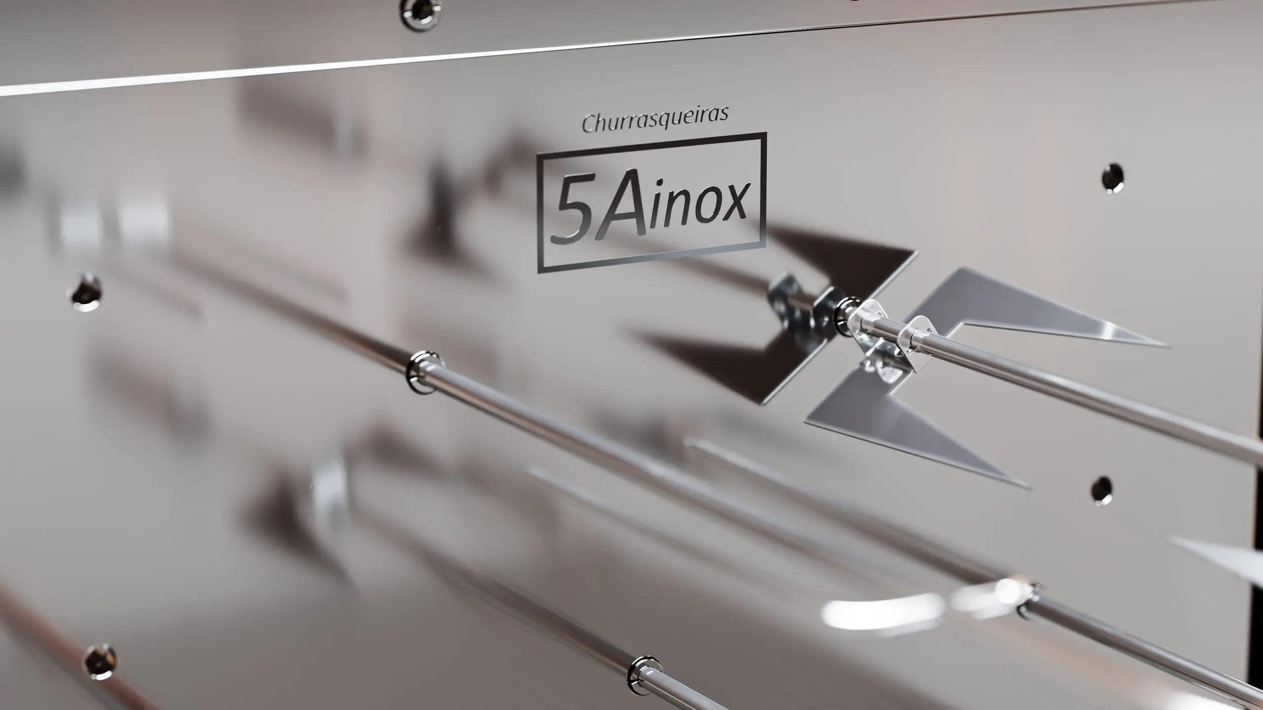 Chapa de aço inox com a marca 5A Inox gravada e espetos giratórios
